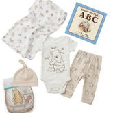 Baby clothing set with Winnie the Pooh design, including onesie, pants, hat, and blanket, with a book titled 'Winnie the Pooh's ABC' on a white background.