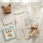 Baby clothing set with bear-themed items on a wooden surface