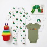 A baby clothing set featuring a white long-sleeve footless sleeper with a green caterpillar print, an olive green short-sleeve bodysuit with colorful fruit prints and 'They Bit My Hand!' text, a white short-sleeve bodysuit with 'The Very Busy Caterpillar' book cover, and a rainbow stacking toy.