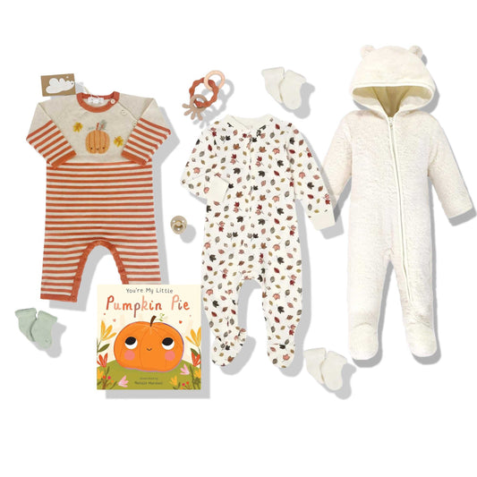 Collection of baby clothing and a book with a pumpkin design on a white background
