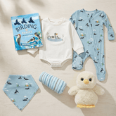 Collection of baby clothing and items with bird-themed designs on a neutral background
