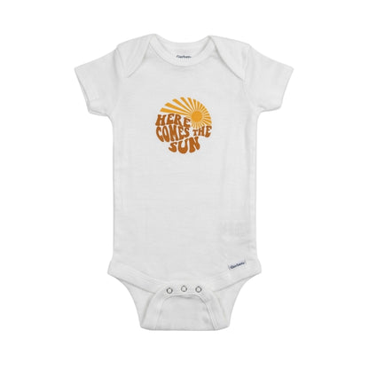 White baby onesie with 'Here Comes the Sun' text and sun graphic on a white background