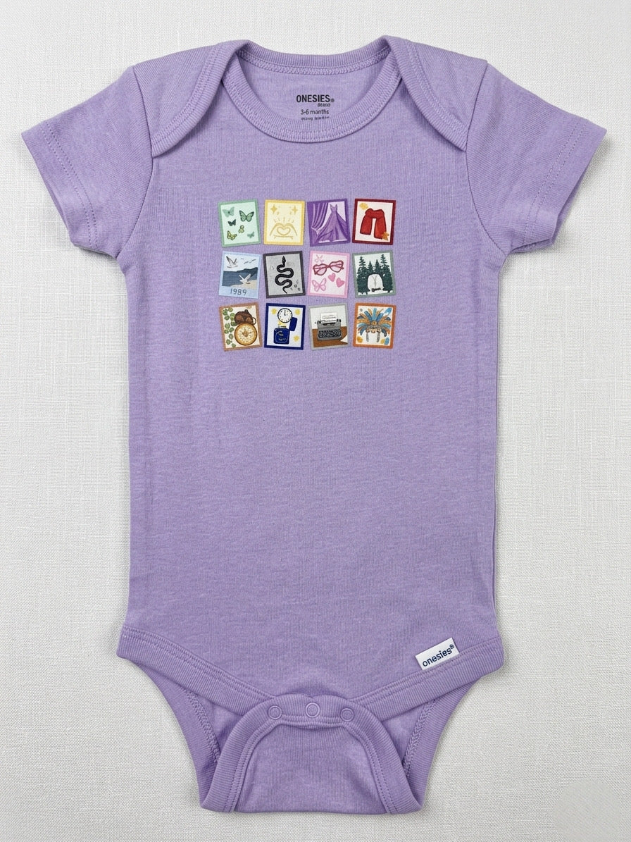 Purple baby onesie with colorful graphic on a light gray background
