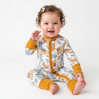 Baby wearing a colorful animal print onesie with yellow accents on a white background