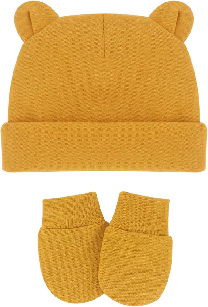 A mustard yellow knit baby hat with bear ears and a folded cuff, shown with matching knit baby mittens on a plain white background.