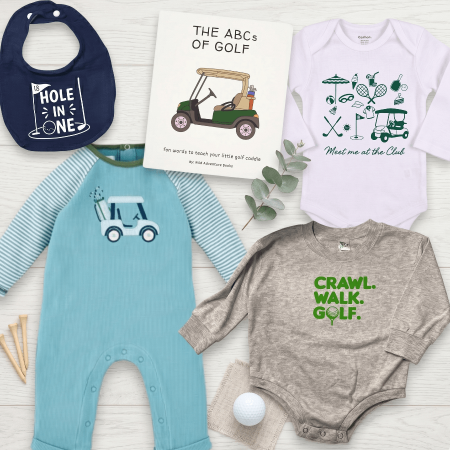 Collection of children's clothing and a book with golf-themed designs on a light wooden surface.