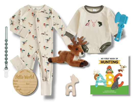Collection of baby items including pajamas, plush deer, and educational book on a white background