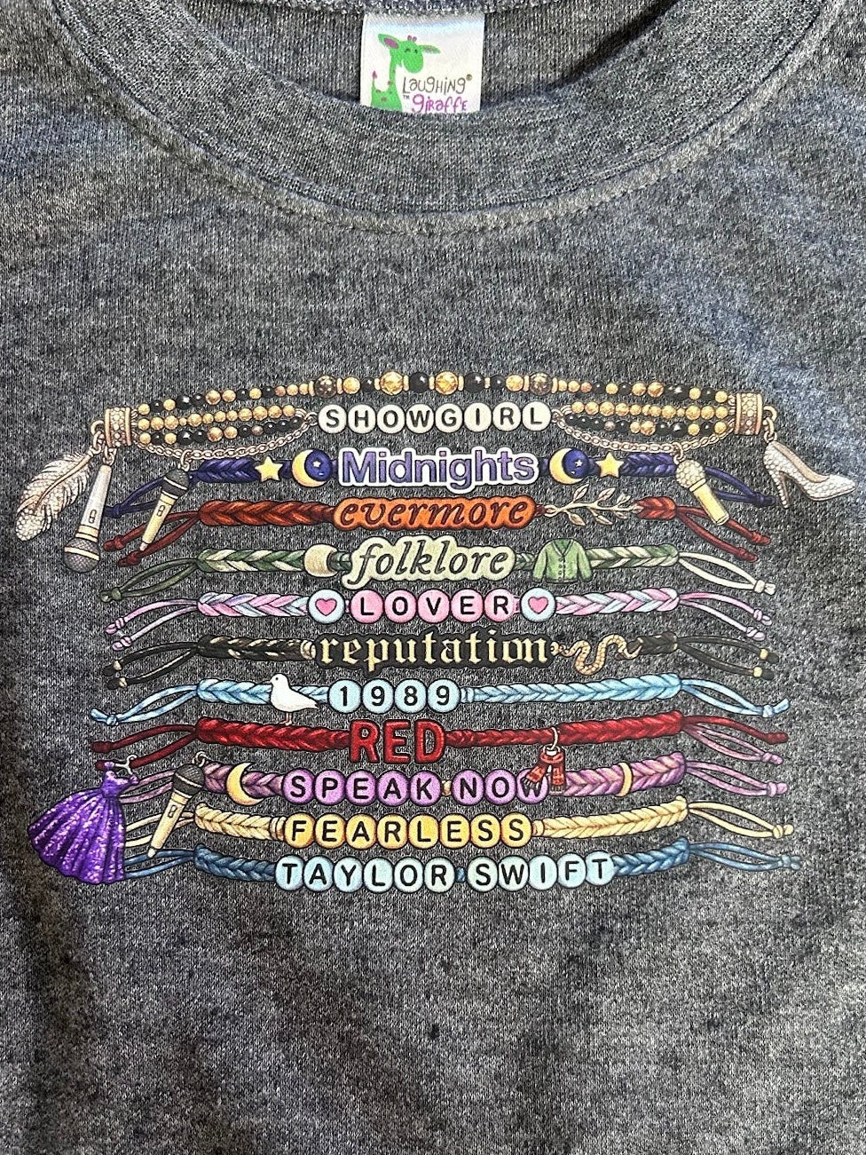 Gray sweatshirt with colorful embroidered text and designs on a dark background