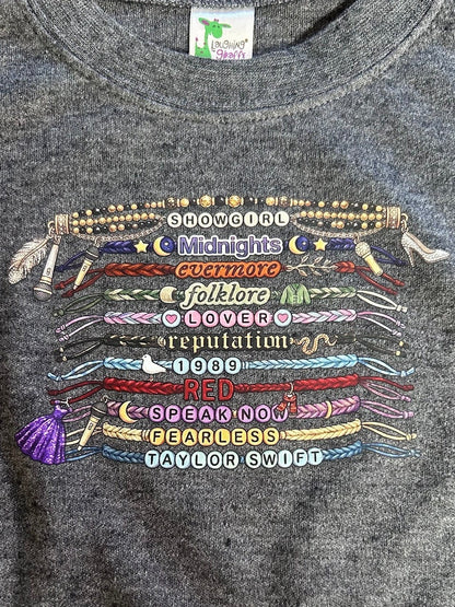 Gray sweatshirt with colorful embroidered text and designs on a dark background
