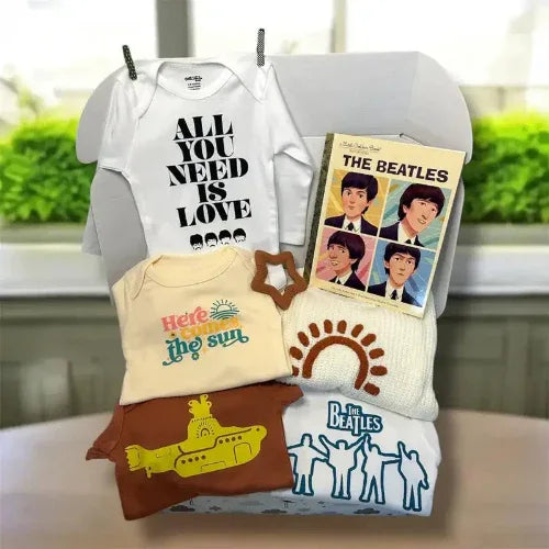 Collection of Beatles-themed t-shirts and a book on a chair with a blurred background