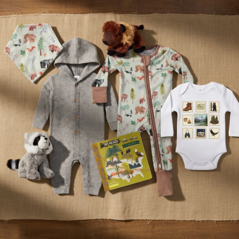 Collection of baby clothing and toys on a brown surface