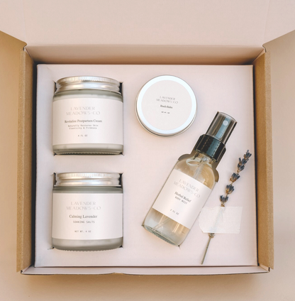 Set of skincare products including a candle, cream, and spray bottle in a box.