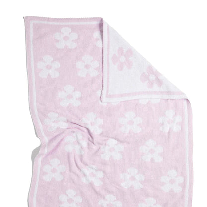 Pink chenille blanket with white floral pattern on a white background