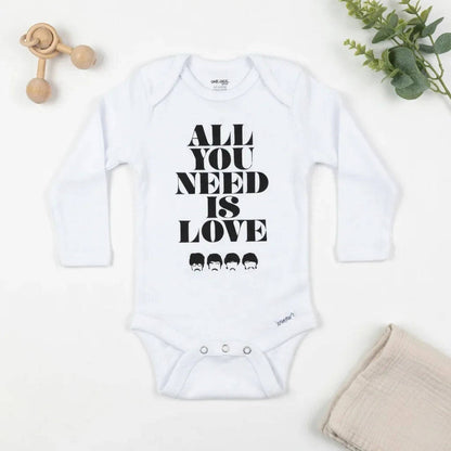 White baby onesie with 'All You Need Is Love' text on a white background