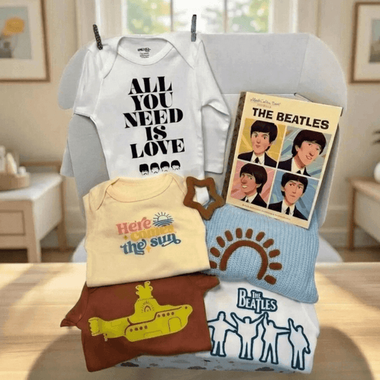 Collection of baby clothing and Beatles-themed items on a table.