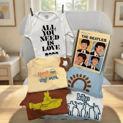 Collection of baby clothing and Beatles-themed items on a table.