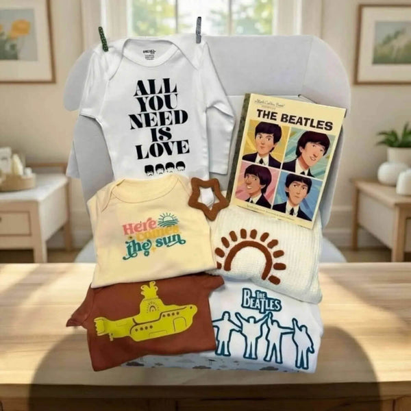 Collection of baby clothing and 'The Beatles' memorabilia on a chair.