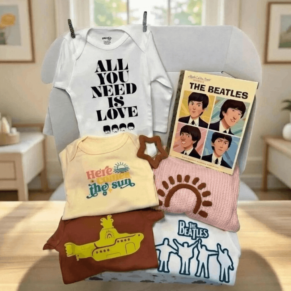 Collection of baby clothing and items with 'The Beatles' design on a table.