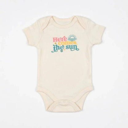 Beige baby onesie with 'Here comes the sun' text on a white background