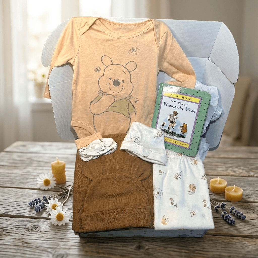 Baby clothing and items with a bear design on a wooden table.