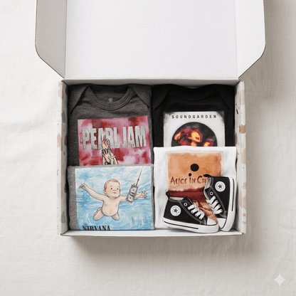 A curated gift box containing music merchandise, including a Pearl Jam t-shirt, a Soundgarden t-shirt, a Nirvana graphic print, an Alice in Chains print, and a pair of black canvas sneakers, all arranged inside an open white box.