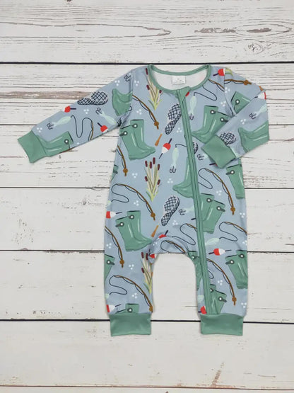 Children's onesie with green wellington boots and nature-themed print on a wooden surface