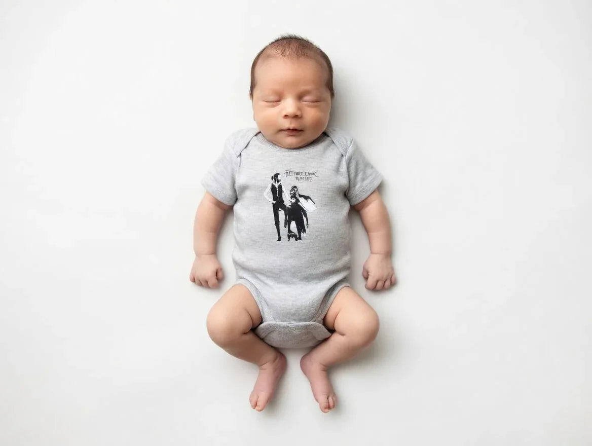 Newborn baby wearing a gray onesie with a graphic design on a white background
