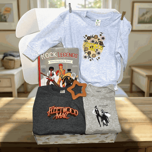 Three t-shirts with 'Fleetwood Mac' design on a table in a room.