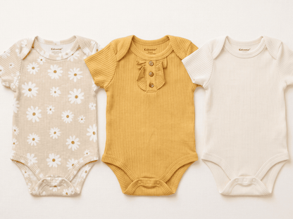 Three baby bodysuits in different styles on a white background