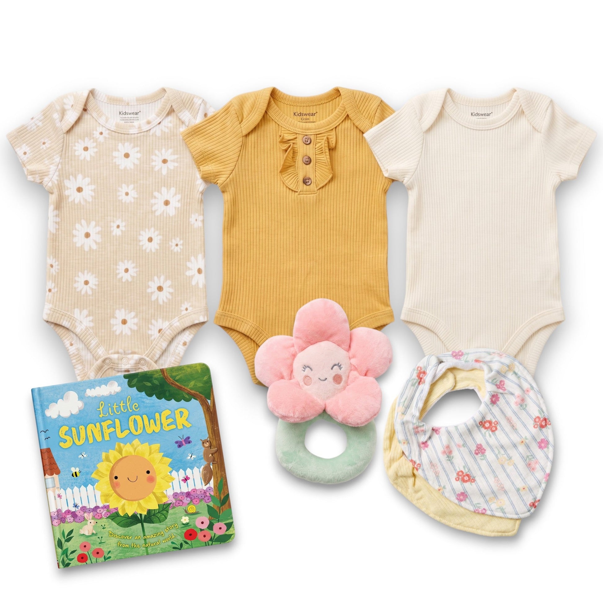 Collection of baby clothing, toys, and a book on a white background