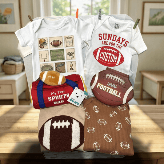 Baby clothing set with sports-themed items on a wooden table.