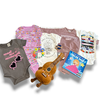 Collection of baby clothing, toys, and books on a white background