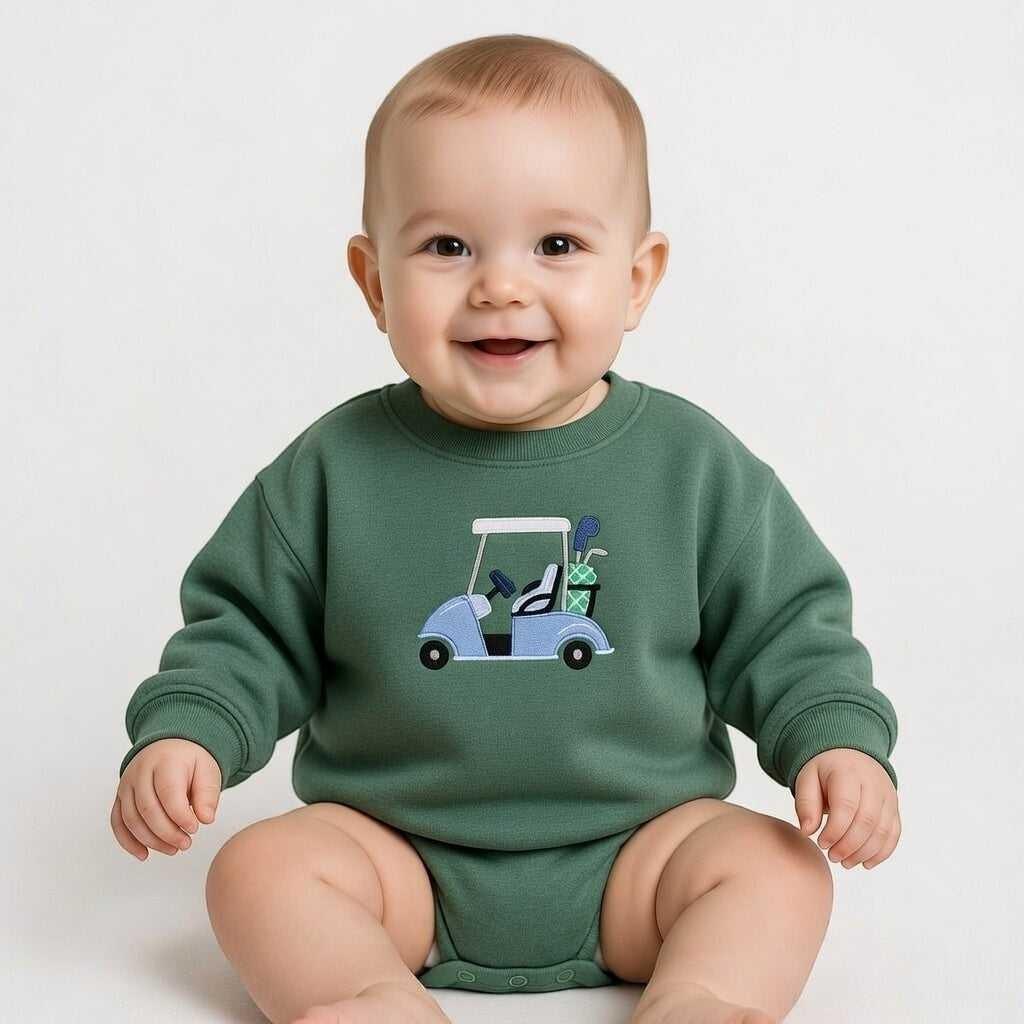 Baby wearing a green long-sleeved bodysuit with a blue golf cart embroidered on the front. The golf cart has golf clubs in the back.