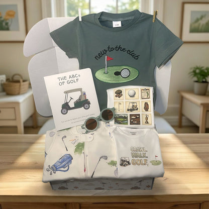 Baby clothing and accessories set with t-shirt, shorts, and books on a chair.