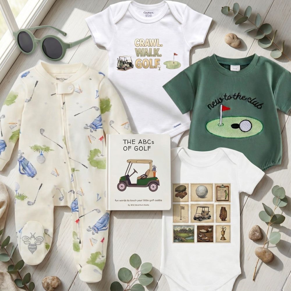 Collection of children's clothing and a book titled 'The ABCs of Golf' on a light wooden surface with greenery.