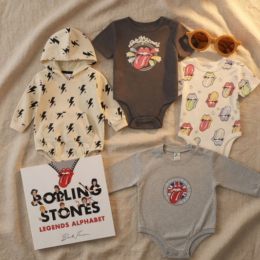 Hey Baby Box Rolling Stones inspired baby gift set with four onesies and a book. Includes grey, multi-colored lips, and black logo designs.