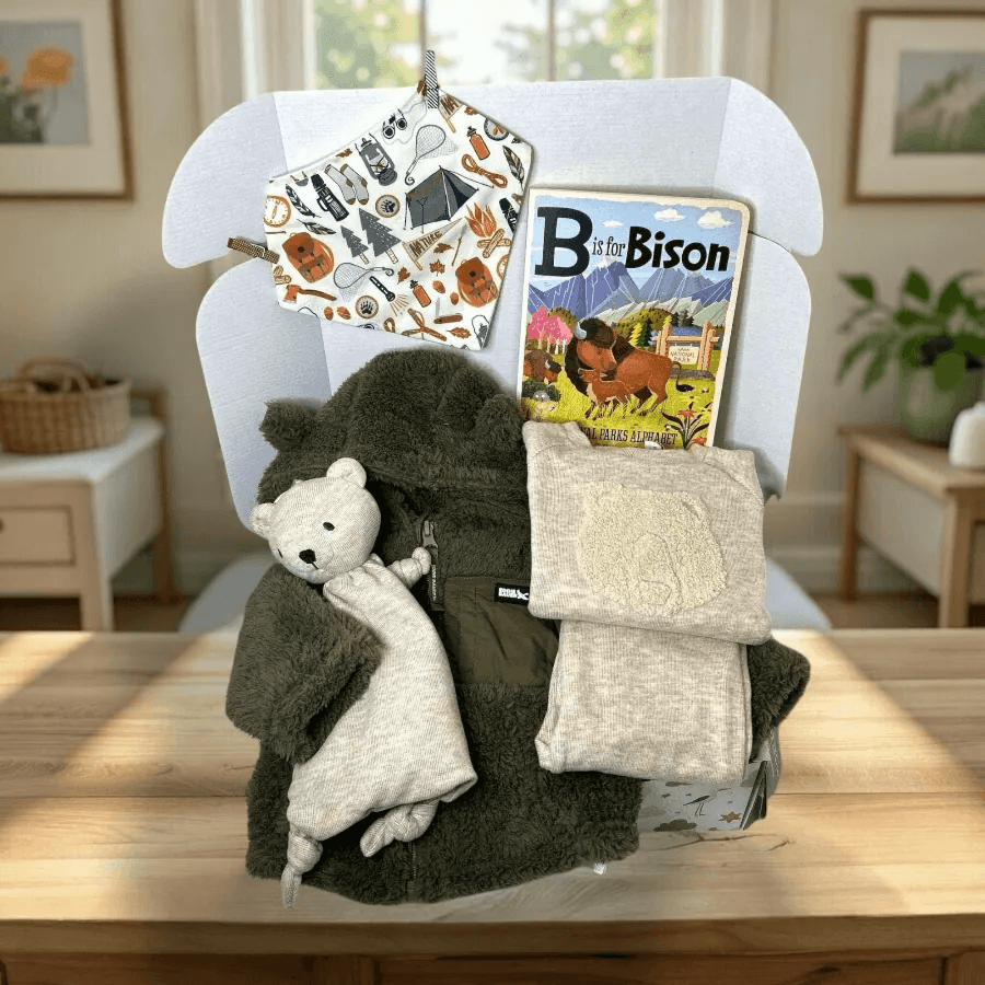 Baby items including a hat, blanket, and book on a chair in a home setting
