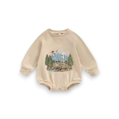 Hey Baby Box beige long-sleeve baby romper with a graphic print of a bison, pine trees, mountains, and a river.
