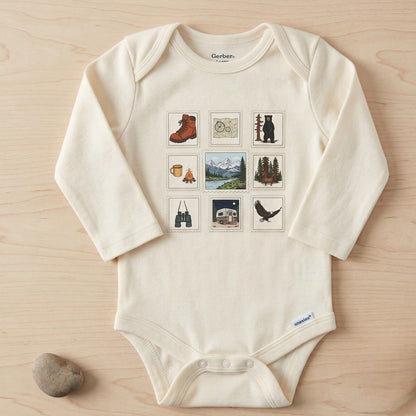 White baby onesie with nature-themed graphics on a wooden surface