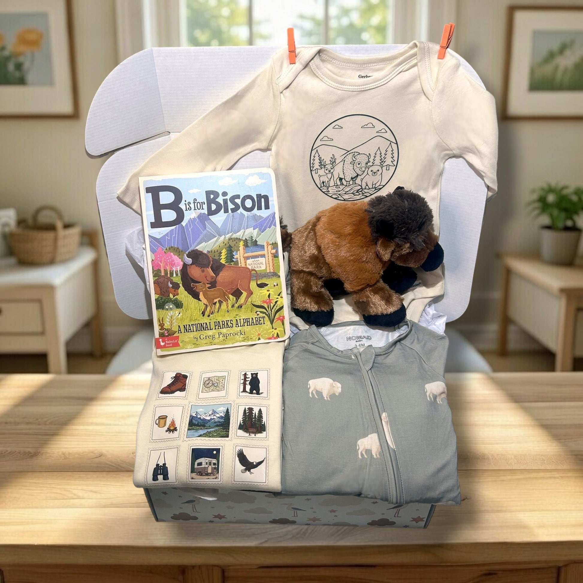 Baby clothing and toys with a book on a chair in a room setting