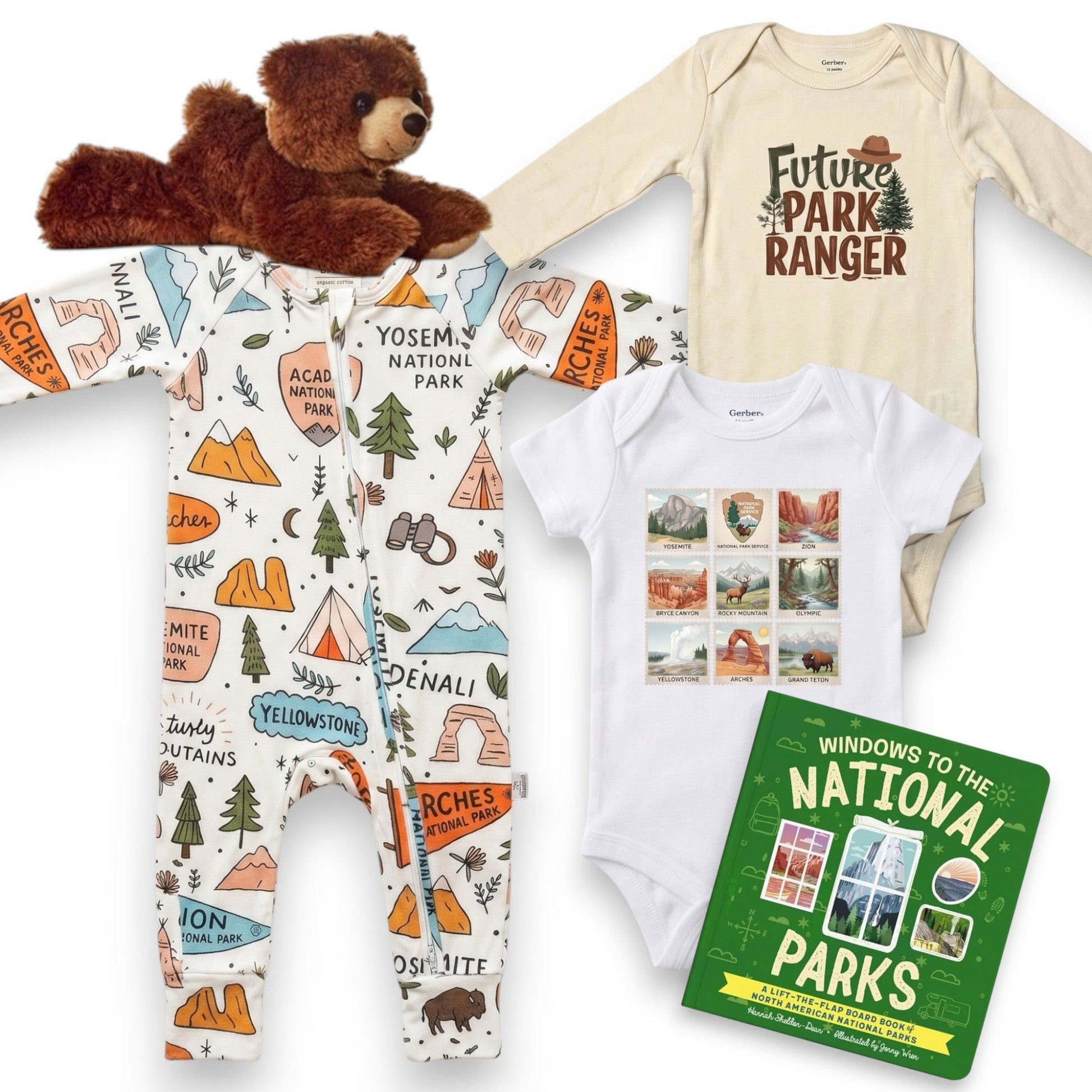 Baby onesie with national park design, teddy bear, and book on a white background