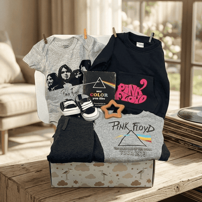 Collection of Pink Floyd merchandise including t-shirts and a book on a wooden table in a living room.