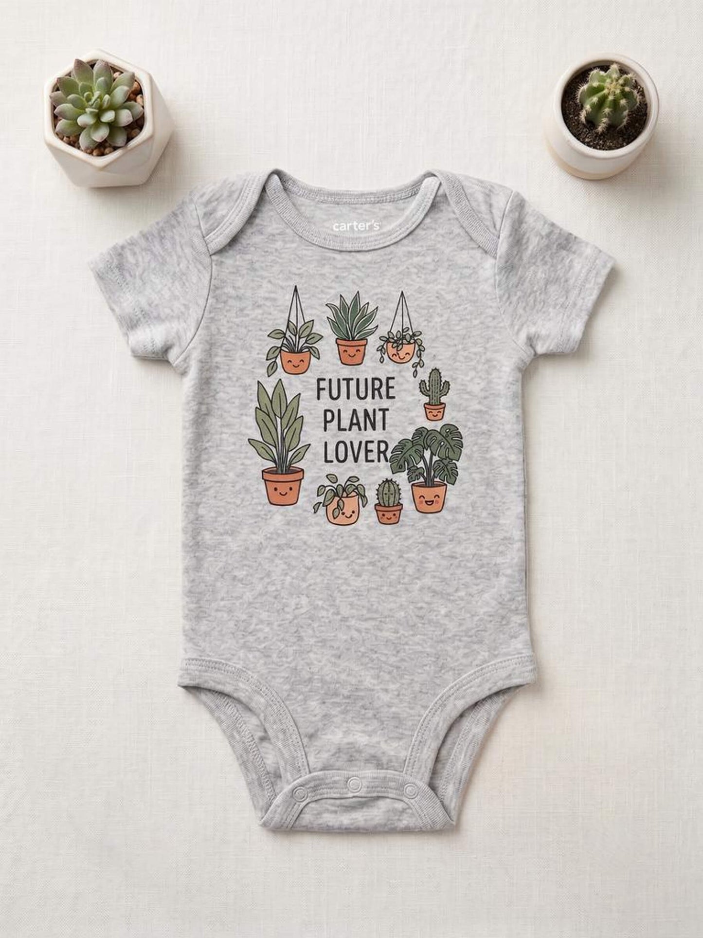 Gray baby onesie with plant-themed design on a light background
