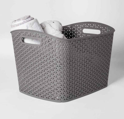 Gray woven storage basket with baby blanket and plush toy, ideal for nursery organization