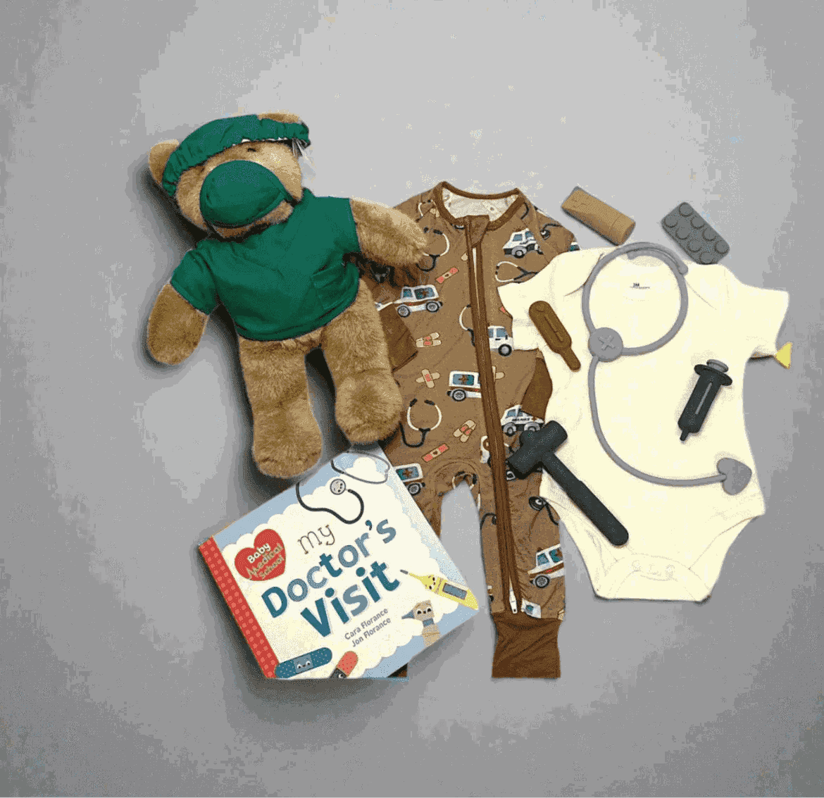 Doctor-themed baby gift set with teddy bear, onesie, toy stethoscope, and 'My Doctor's Visit' book