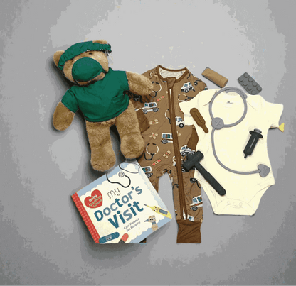 Doctor-themed baby gift set with teddy bear, onesie, toy stethoscope, and 'My Doctor's Visit' book