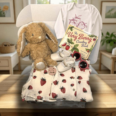 Hey Baby Box strawberry theme baby girl gift set with muslin clothes, onesie, shoes, sunglasses, pacifier, plush bunny, and book.