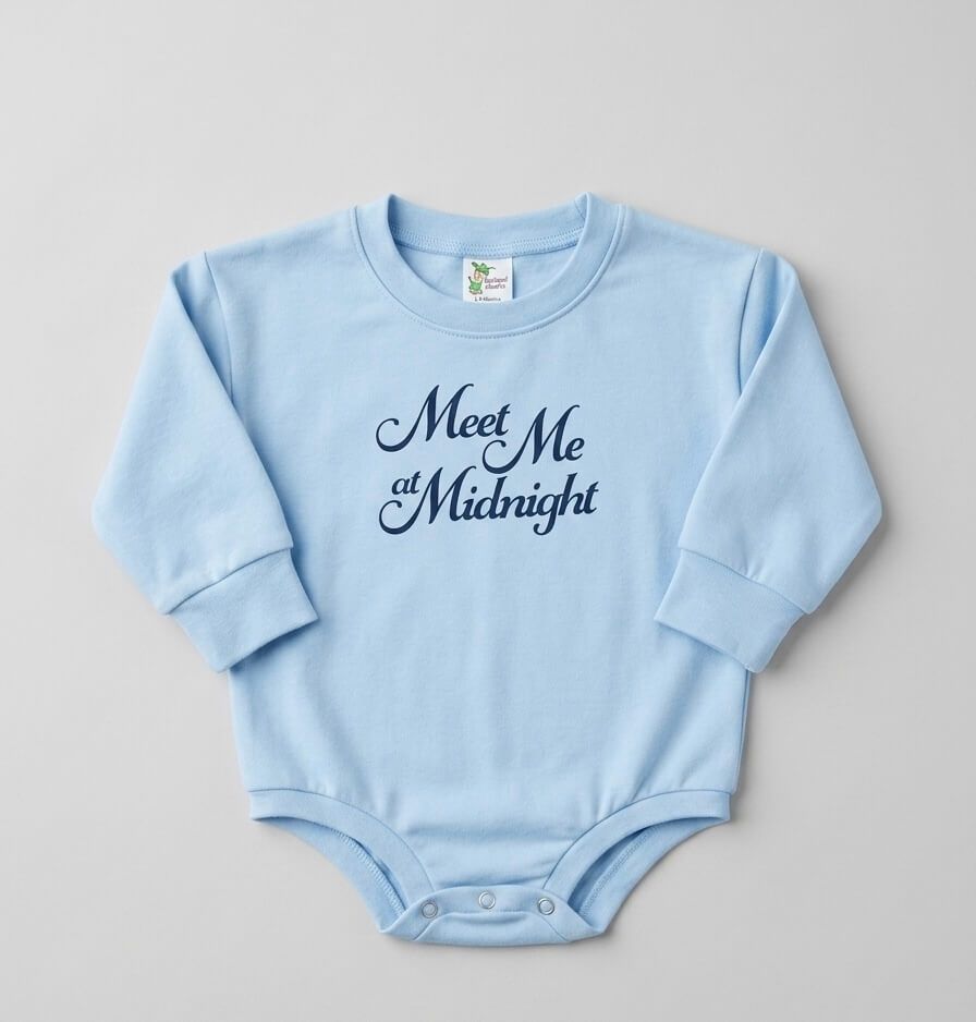 Light blue baby onesie with 'Meet Me at Midnight' text on a gray background