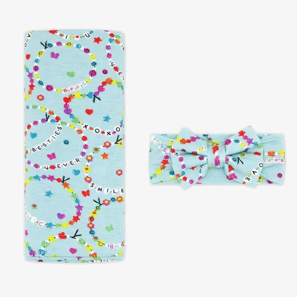 Light blue blanket with colorful patterns and a matching headband on a white background little sleepies