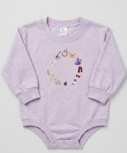Purple baby onesie with embroidered designs on a light gray background